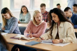 Young students learning together during a class at university classroom.